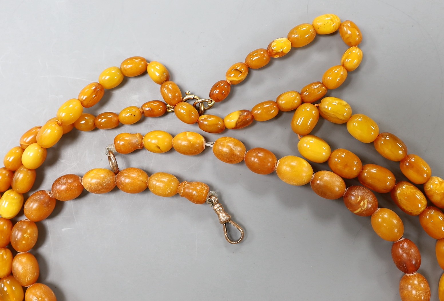 Three assorted amber bead necklaces, longest 112cm, gross weight 115 grams.
